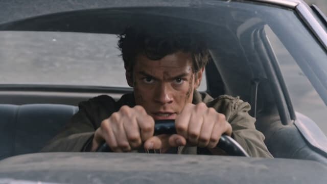 Kling Prompt - A lone survivor driving through chaos, eyes locked, hands gr