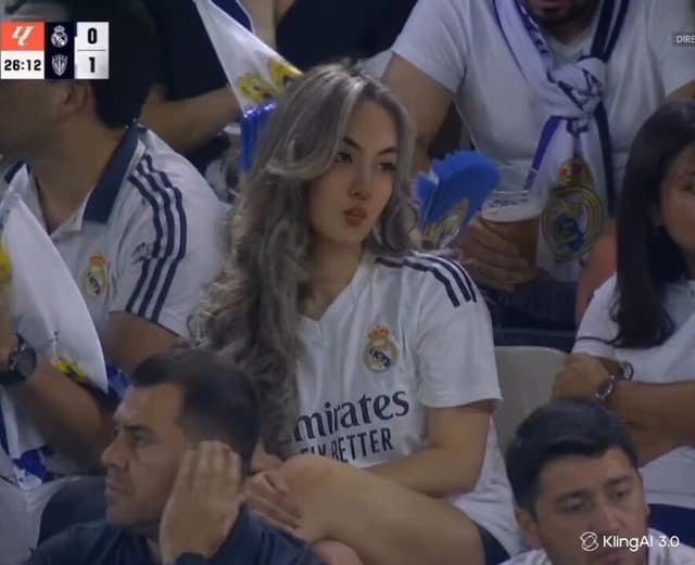 Kling Prompt - A young woman sitting in the crowd at a professional footbal