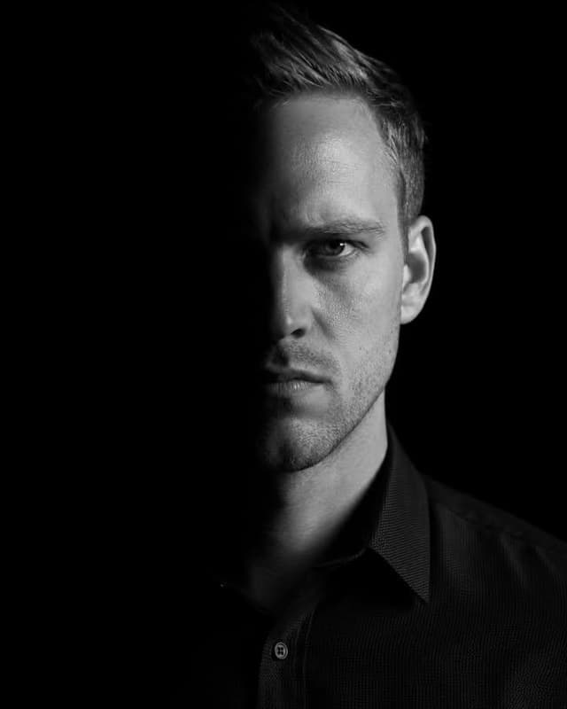 Nano Banana Prompt - A dramatic, high-contrast low-key portrait of a subject. The