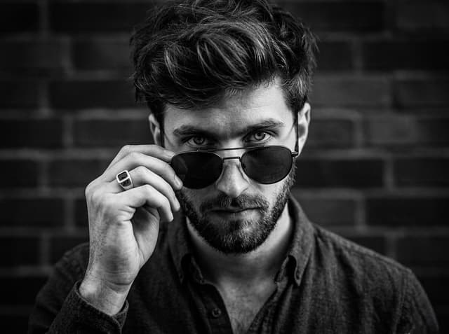 Nano Banana Prompt - A close-up, high-contrast black and white portrait of a man 