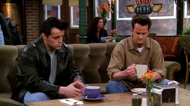 MiniMax Prompt - Joey and Chandler sit side by side on the couch with coffee 