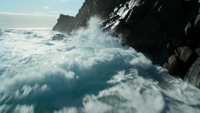 Veo Prompt - The camera begins low near the surging ocean waves, close to
